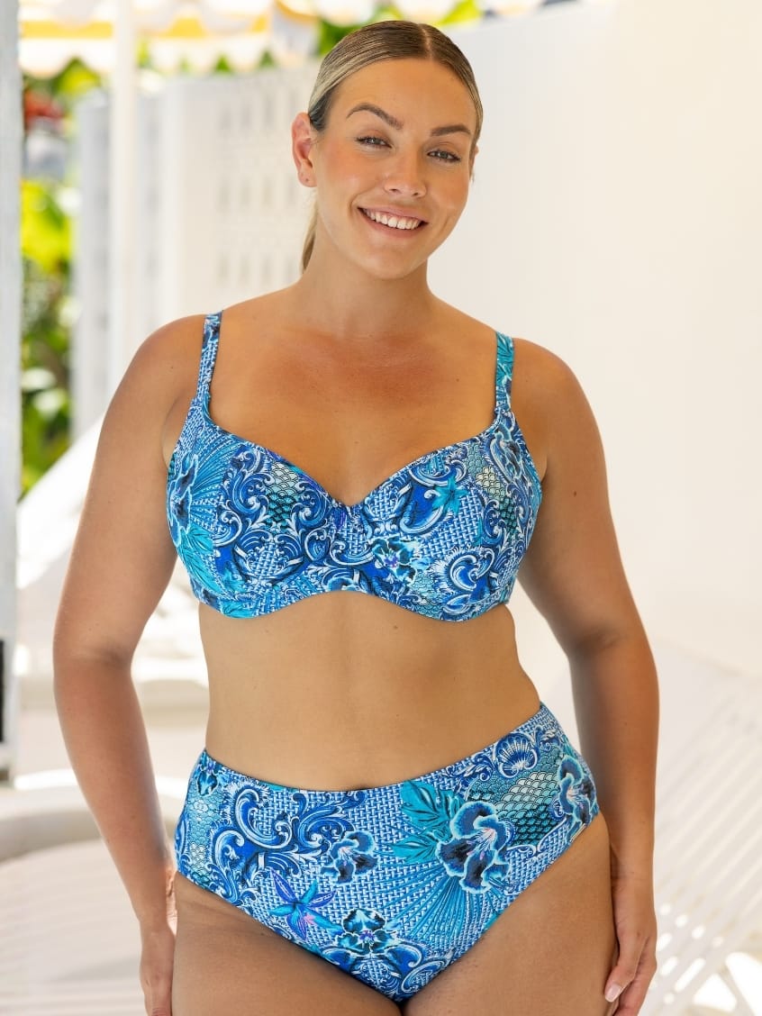 Woman wearing a blue patterned bikini set with a blurred outdoor background