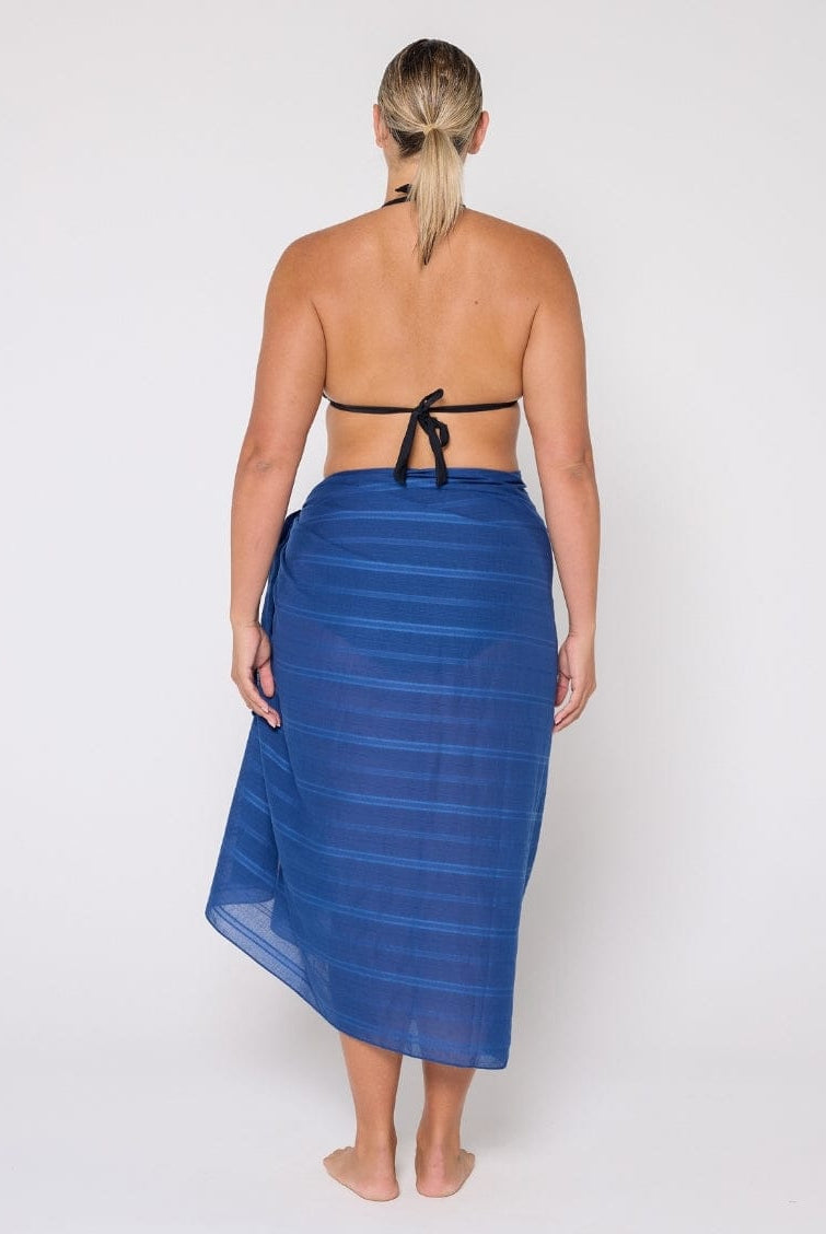 Woman wearing a blue striped sarong on a white background