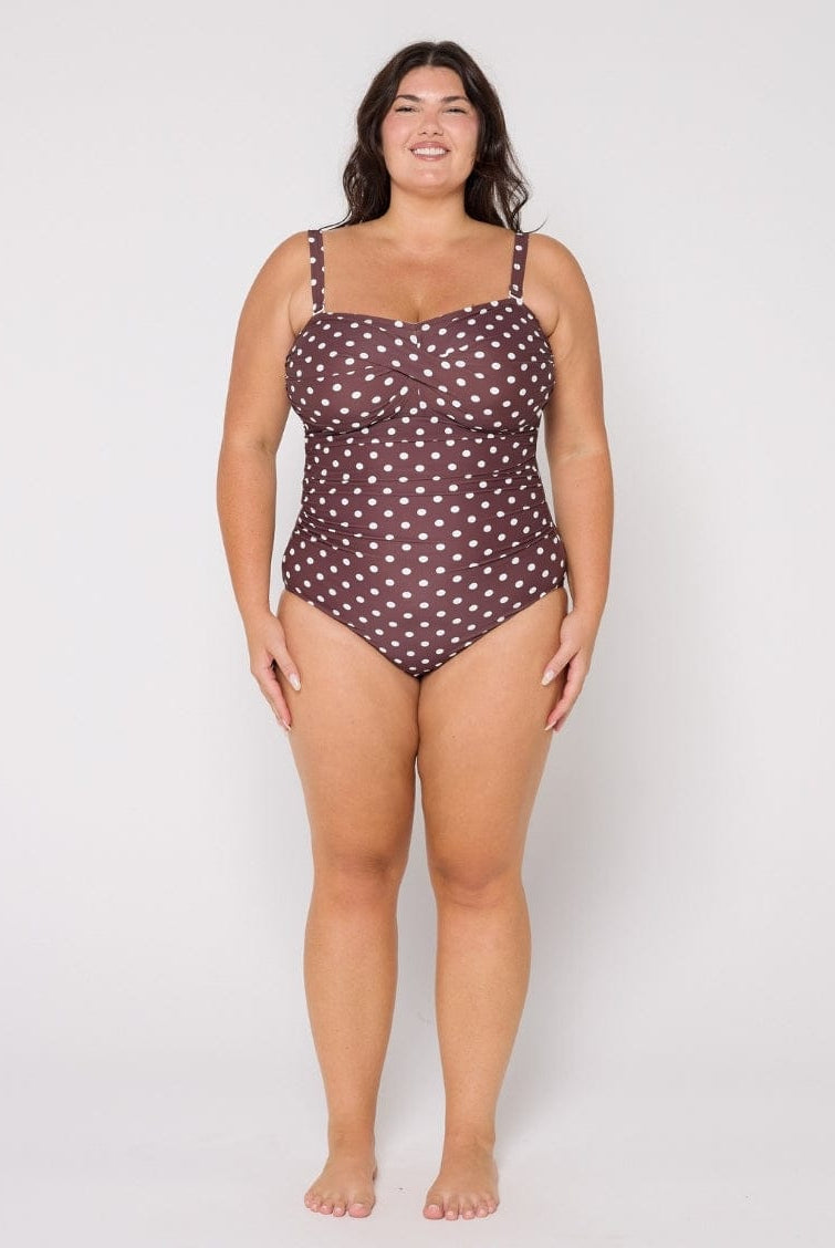 Woman wearing a polka dot swimsuit on a white background