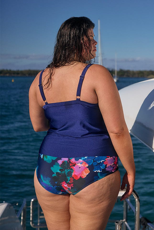 Back of brunette model wearing tiered tankini top with adjustable straps for plus size women