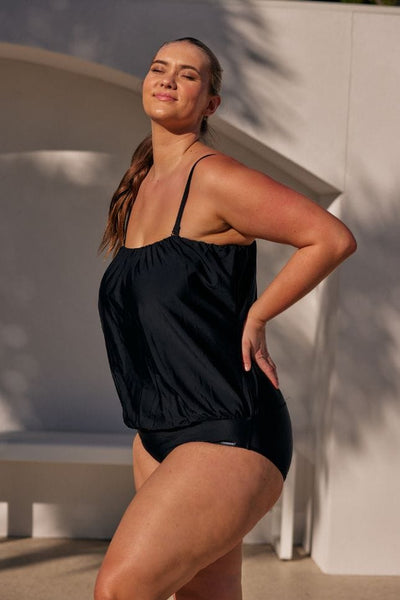 Blonde model wearing black plus size flouncy bandeau one piece swimwear