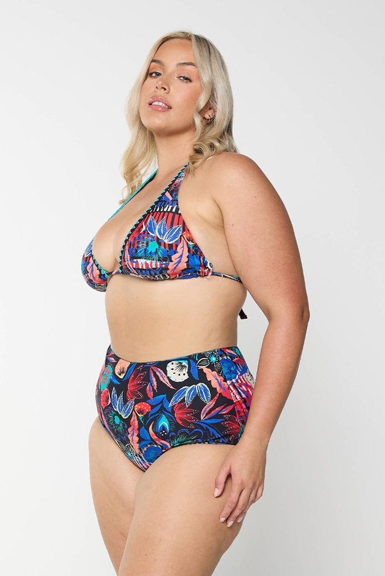 Side profile of curve model in studio wearing tie up triangle bikini top in embroidered multi colour