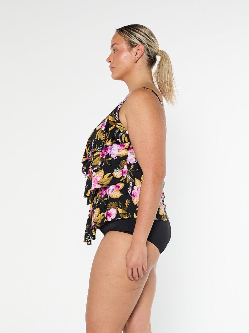 Blonde model shows the side of pink floral chlorine resistant ruffled tankini top