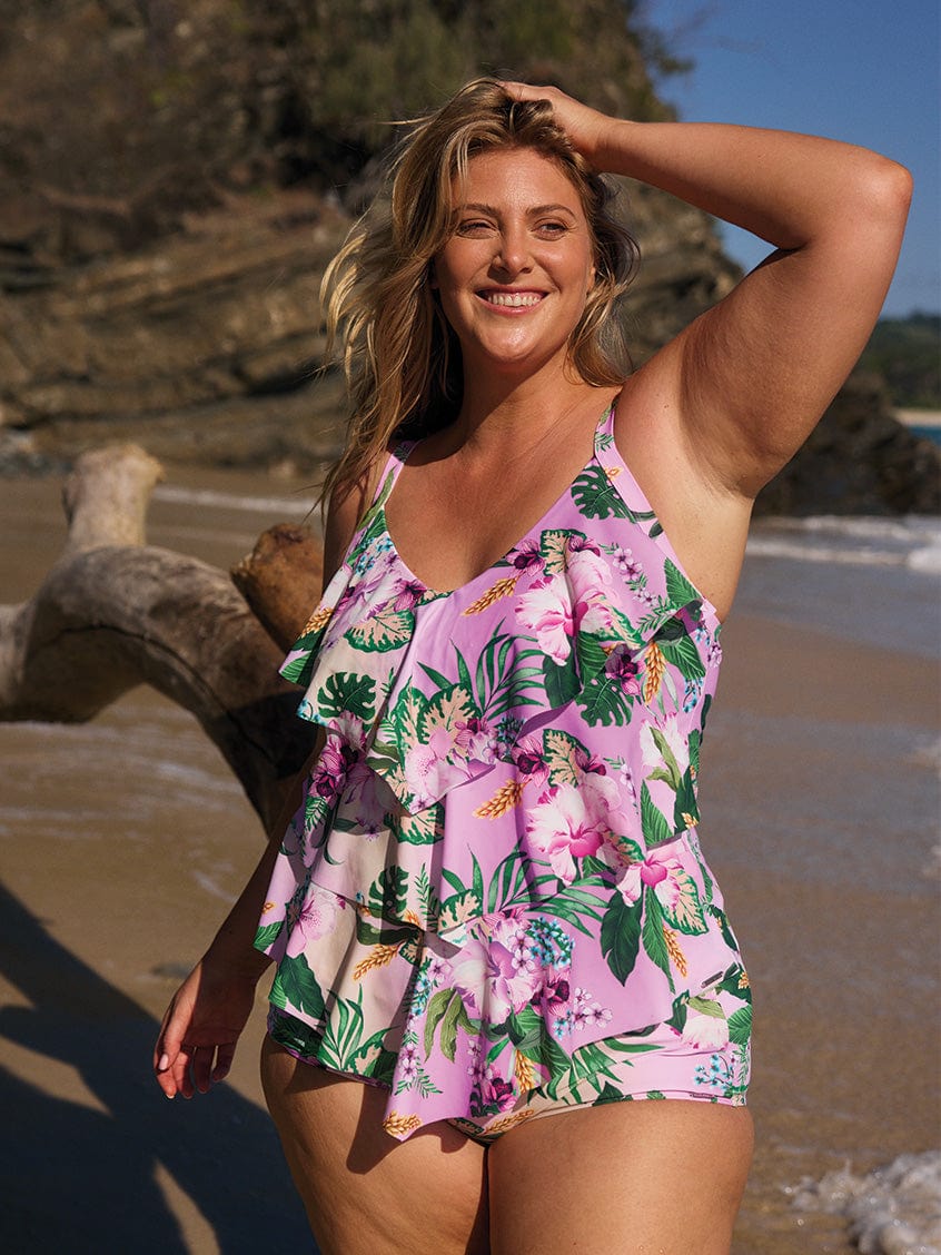 Curve woman standing on beach wearing a tiered tankini