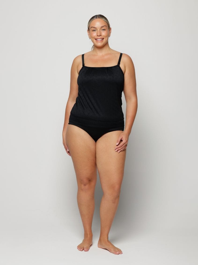 Woman wearing a black swimsuit against a white background