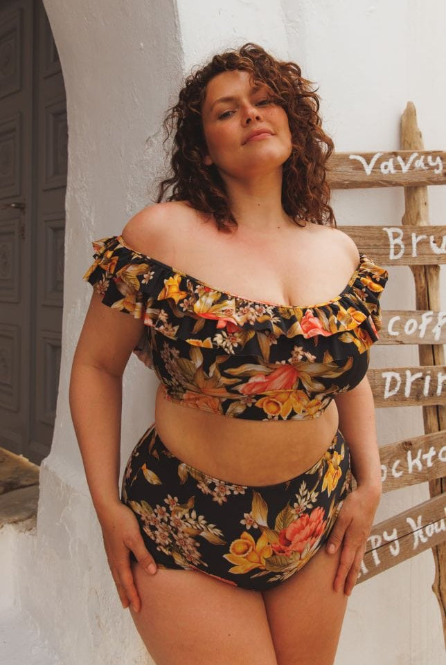 model wearing black floral high waisted swim pant with matching off the shoulder bikini top