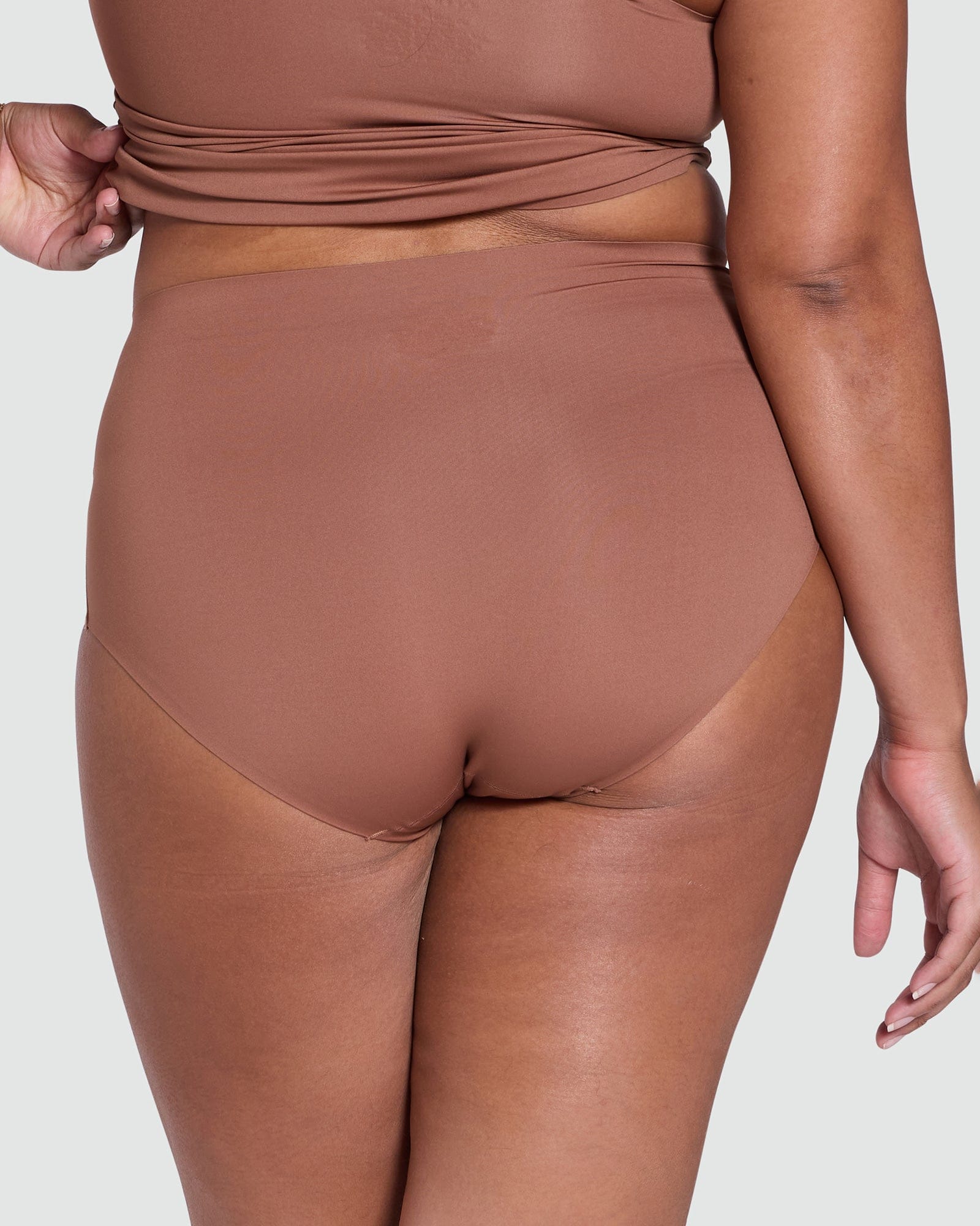 Brown high-waisted brief worn by a person on a white background