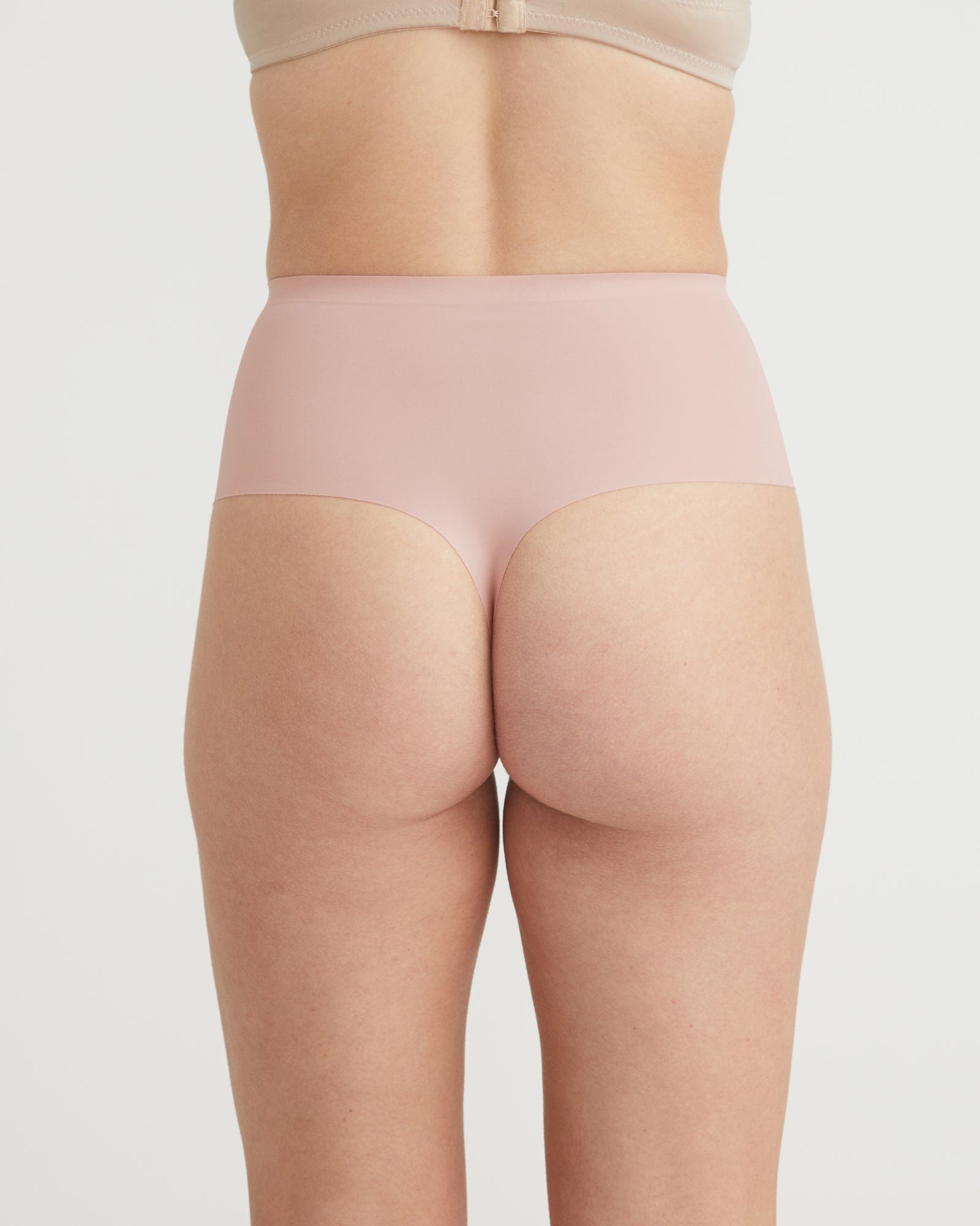 Beige shapewear worn by a person on a light gray background