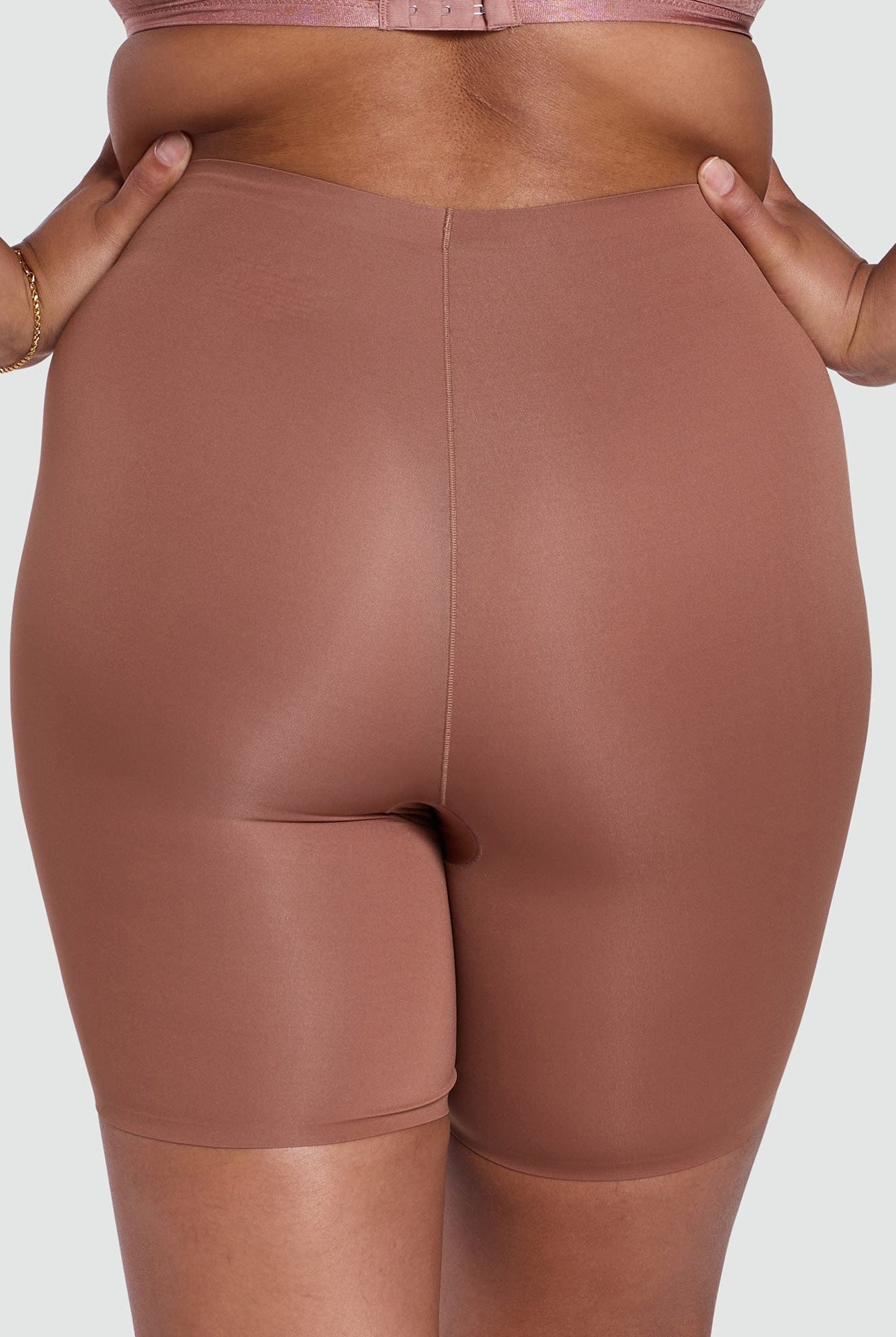 Brown shapewear shorts worn by a person on a plain background