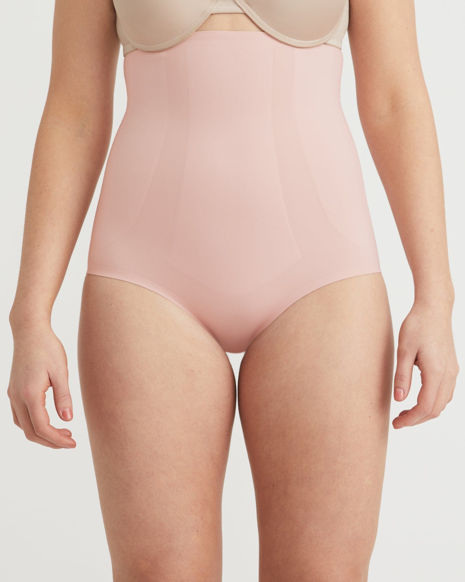 Person wearing a light pink bodysuit on a plain background