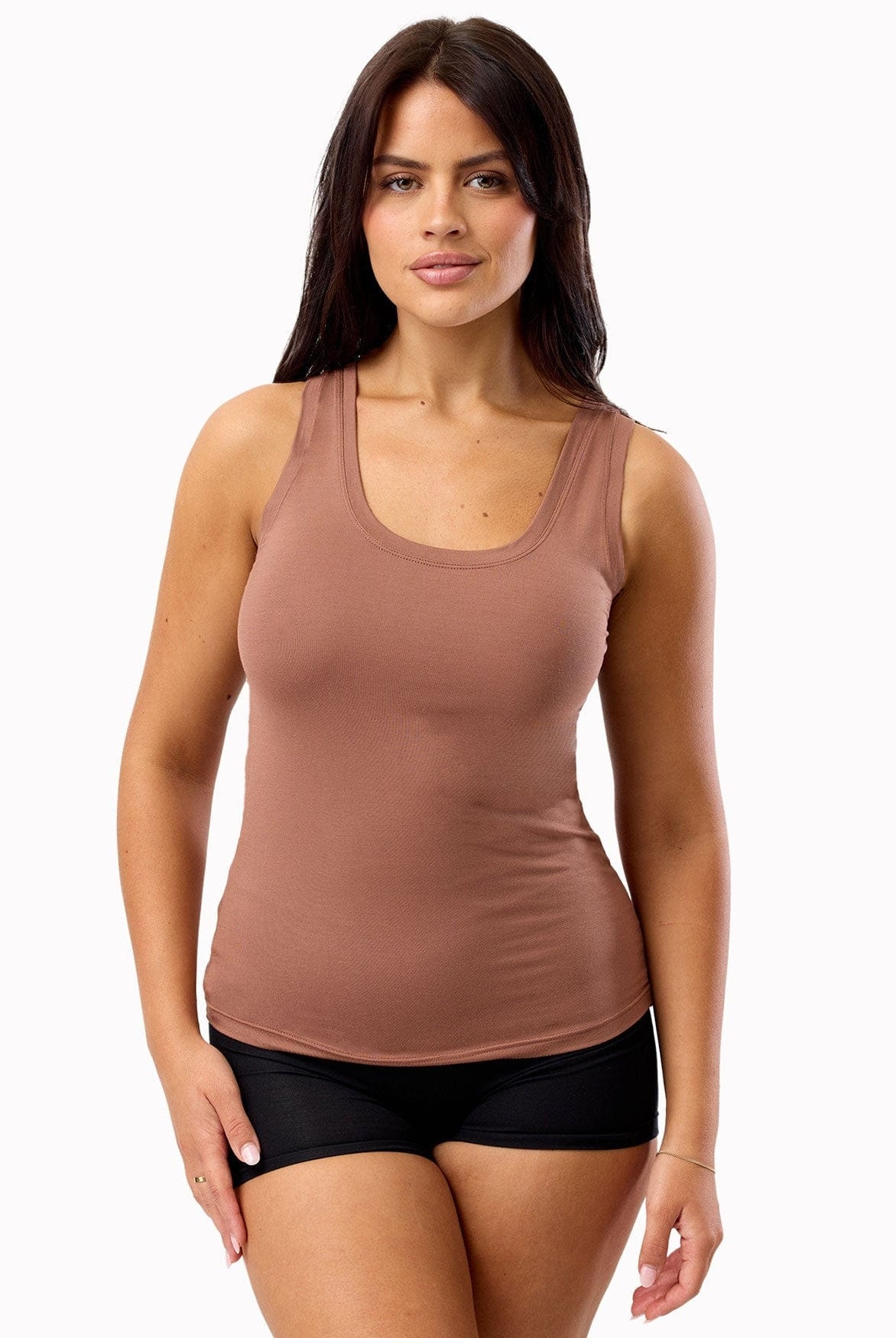 Woman wearing a brown tank top and black underwear on a white background