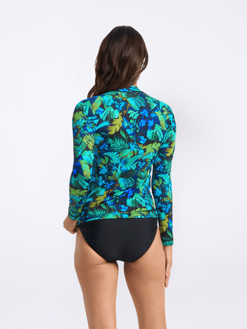 Woman wearing a colorful floral rash guard and black swimsuit on a white background