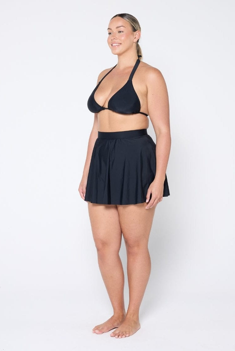 Woman wearing a black two-piece swimsuit on a white background