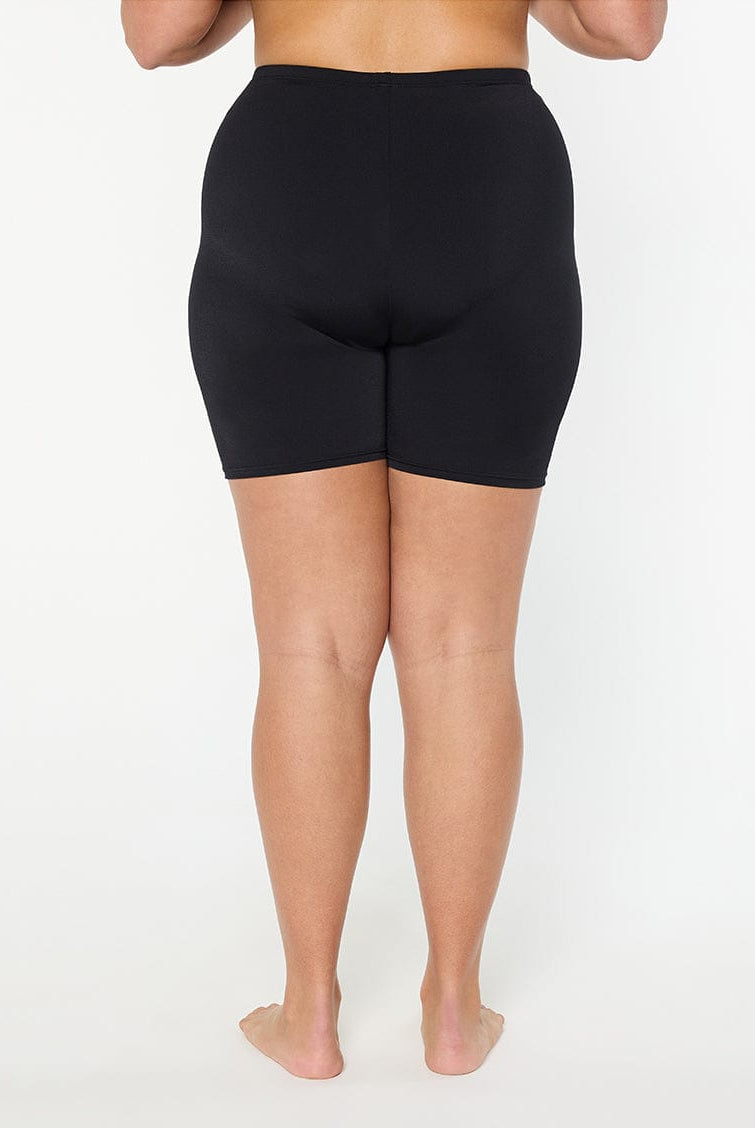 Person wearing black shorts on a white background