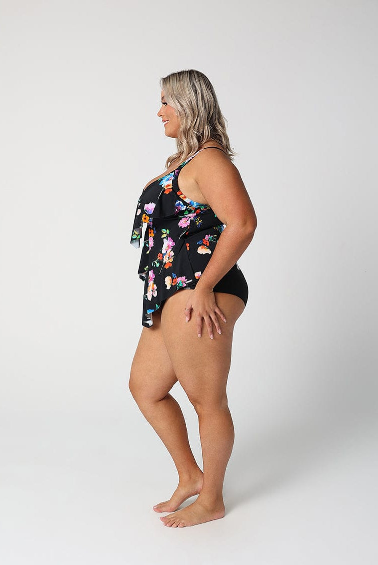 Woman wearing a black floral swimsuit on a white background