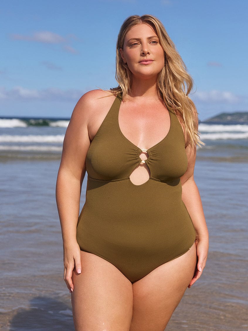 Woman wearing an olive green swimsuit on a beach