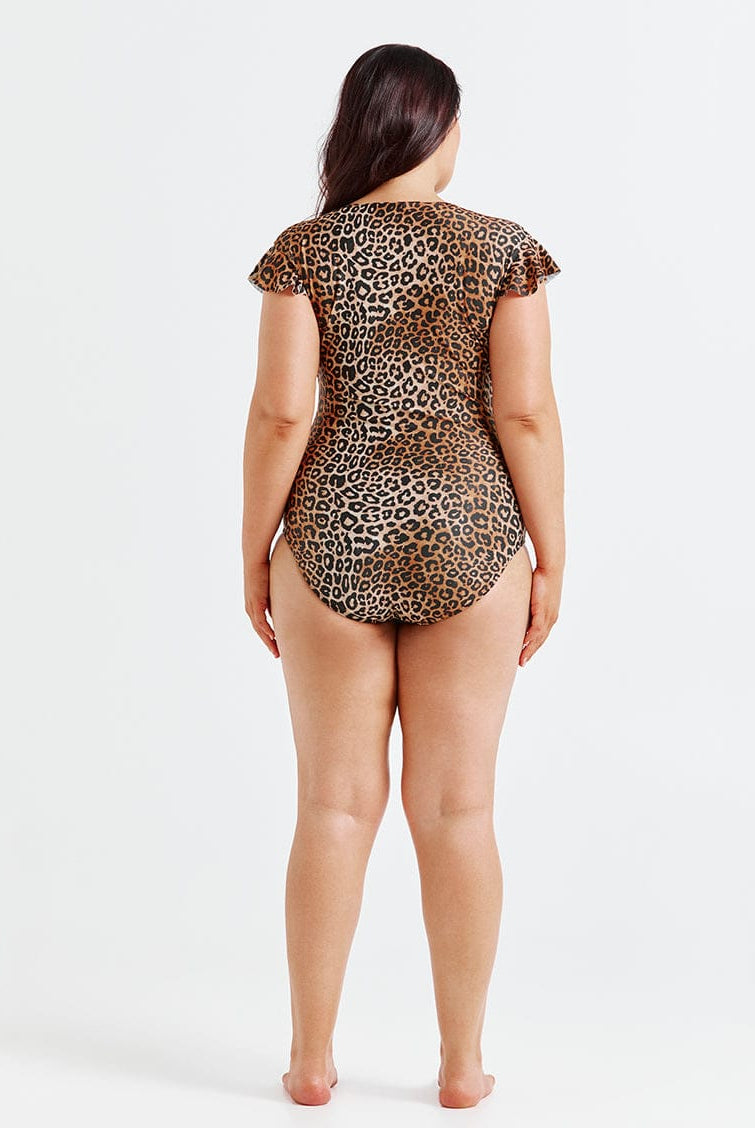 Person wearing a leopard print swimsuit on a white background