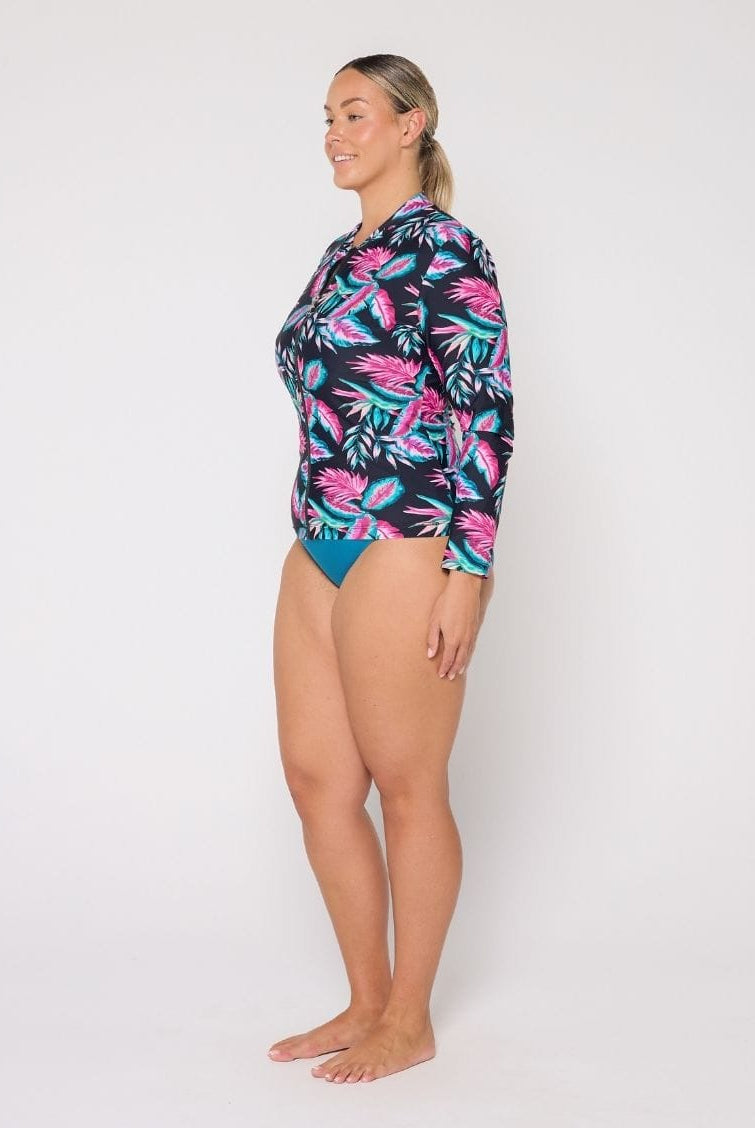 Woman wearing a colorful tropical patterned swimsuit on a white background