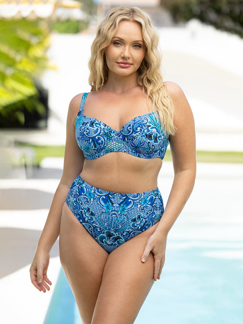 Woman wearing a blue patterned bikini by a pool