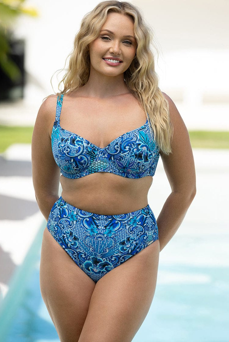 Woman wearing a blue patterned bikini by a pool