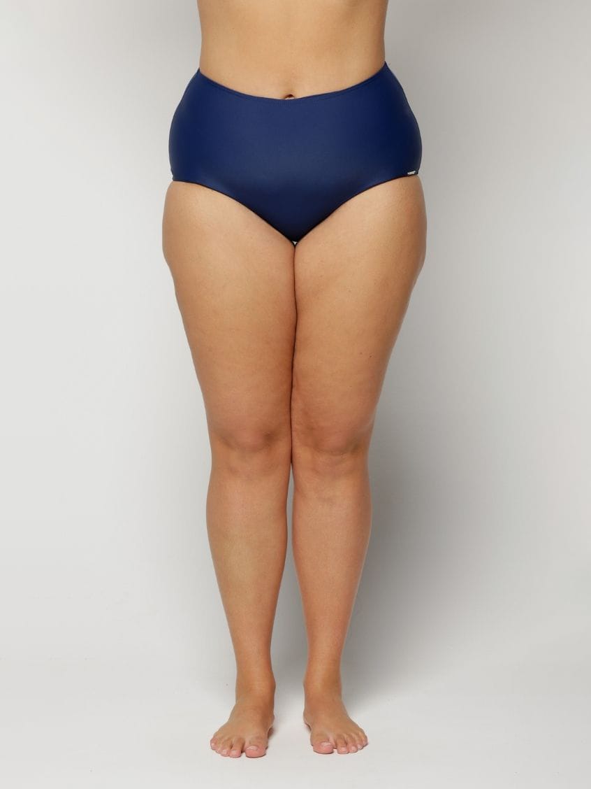 a woman wearing a Navy blue high-waisted swimsuit on a plain background
