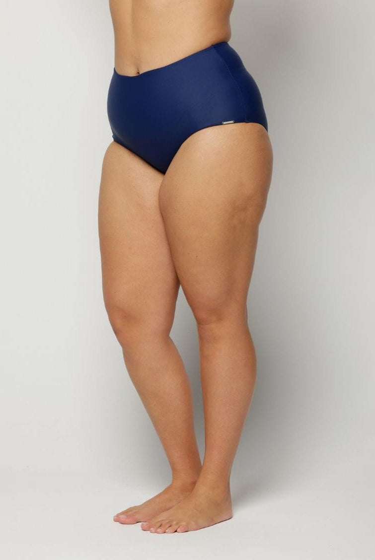 a woman wearing a Navy blue high-waisted swimsuit on a plain background