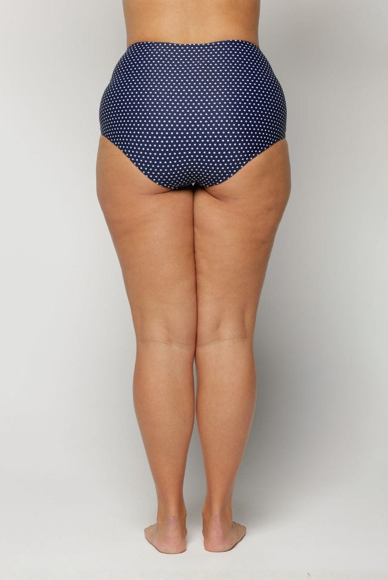 Navy blue polka dot high-waisted bikini bottom on a plain background