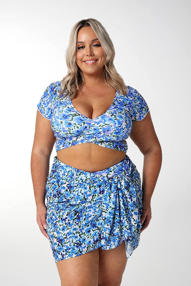 Front of model in studio wearing floral blue sarong
