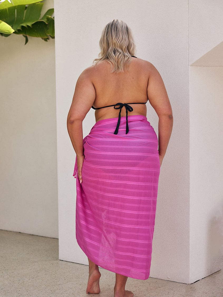 Model showing off back of curve sarong with pom pom detail