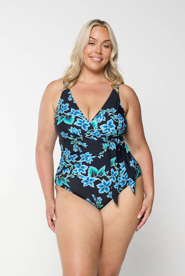 Blonde model wears plus size v neck crossover one piece in blue floral design