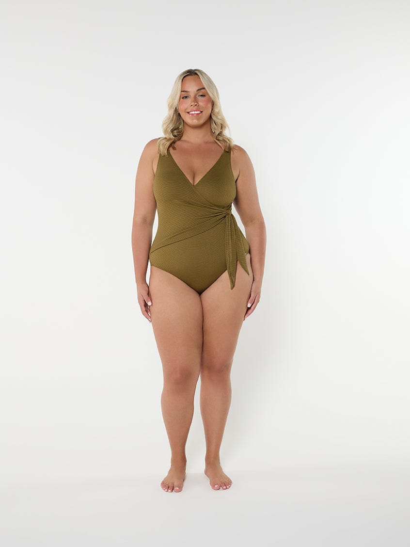 Woman wearing a green swimsuit on a white background