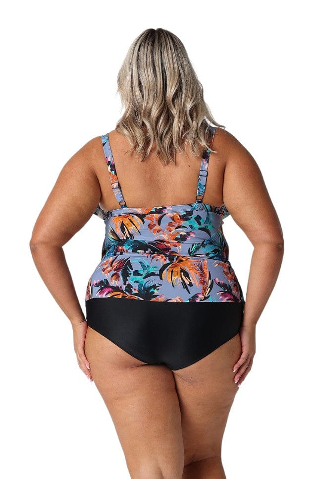 Curve model in studio wearing flattering plus size ruffled tankini top with blue-grey floral tropical print