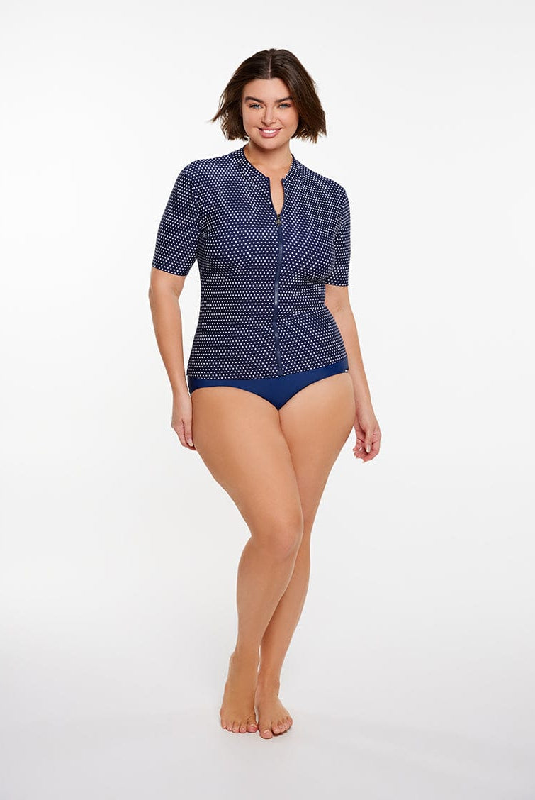 Woman wearing a blue polka dot swimsuit on a white background