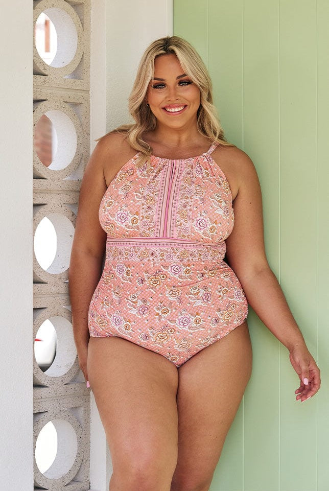 Blonde model wearing pink floral high neck one piece swimsuit