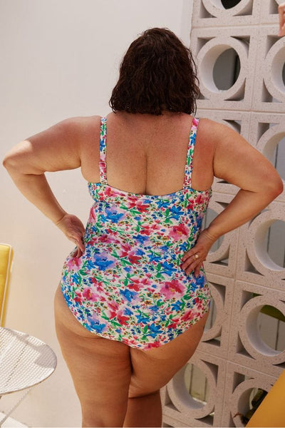 Back of plus size model wearing bandeau one piece with flattering shirring in floral print