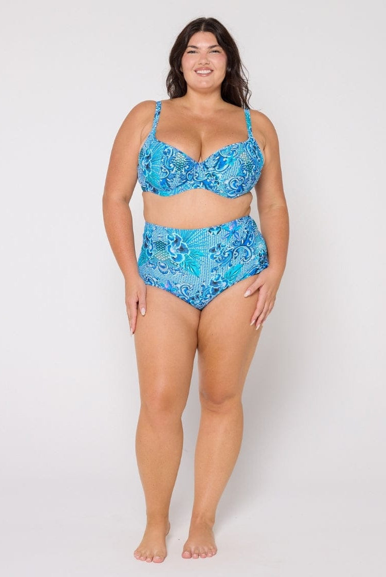 Woman wearing a blue patterned bikini set on a white background