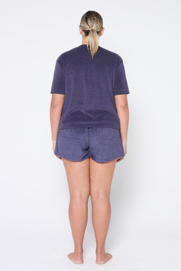 Person wearing navy t-shirt and shorts set on a white background