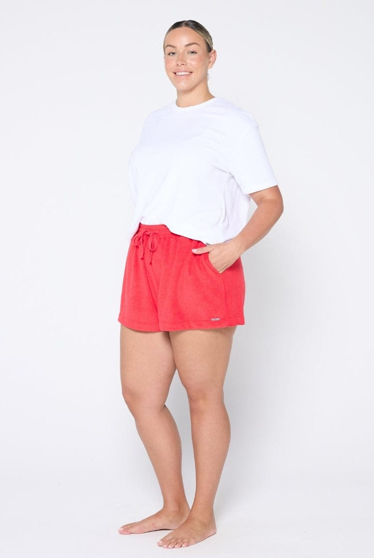 Person wearing red shorts and a white shirt on a white background