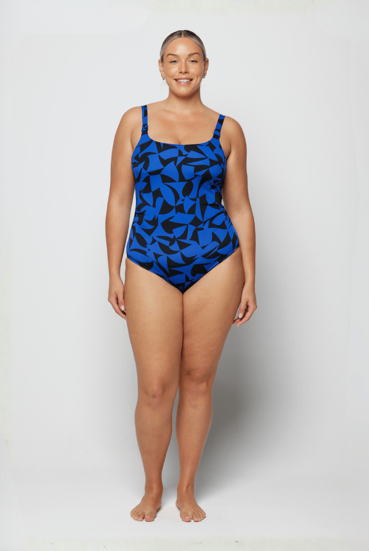 Woman wearing a blue and black patterned swimsuit on a white background