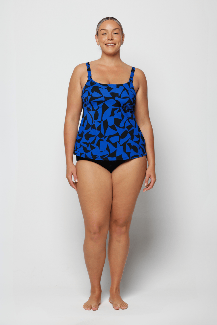 Curve woman wearing a blue and black chlorine resistant tank tankini top in studio