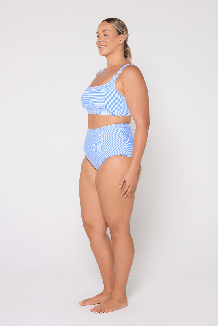 Woman wearing a light blue bikini set on a white background