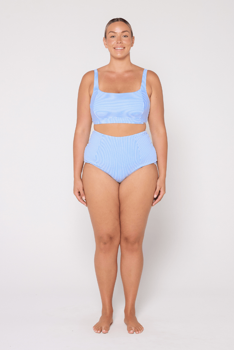 Woman wearing a light blue bikini set on a white background
