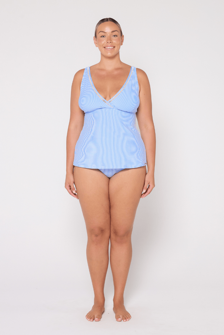 Woman wearing a light blue swimsuit against a white background
