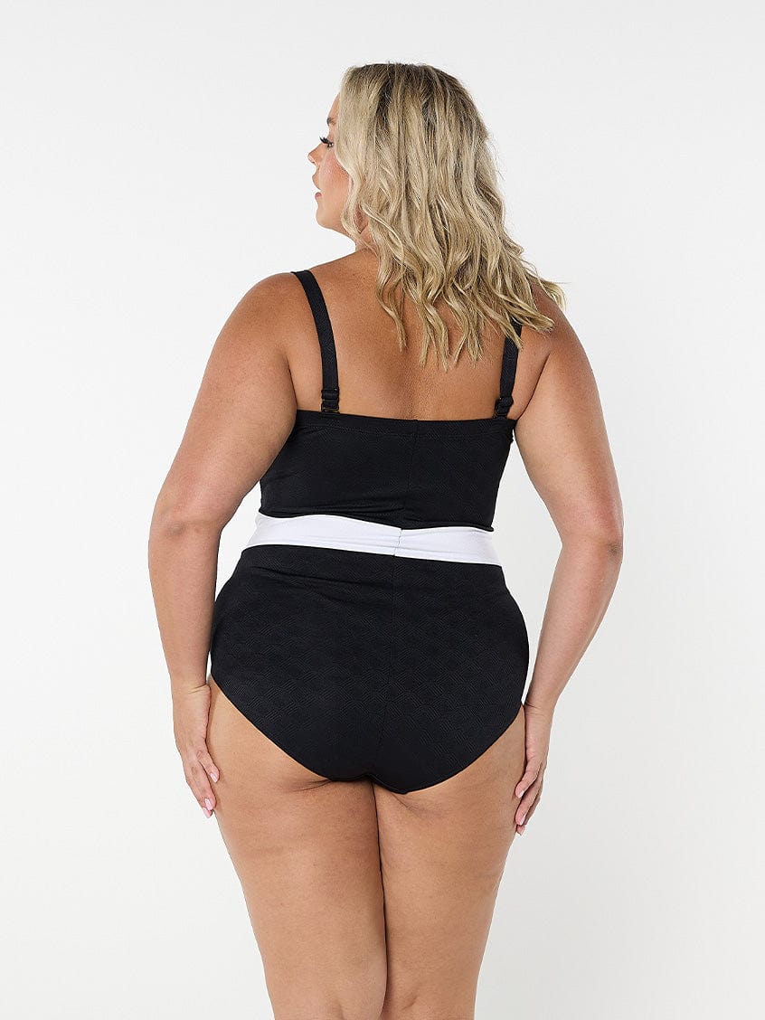 Woman wearing a black swimsuit with a white waistband on a white background