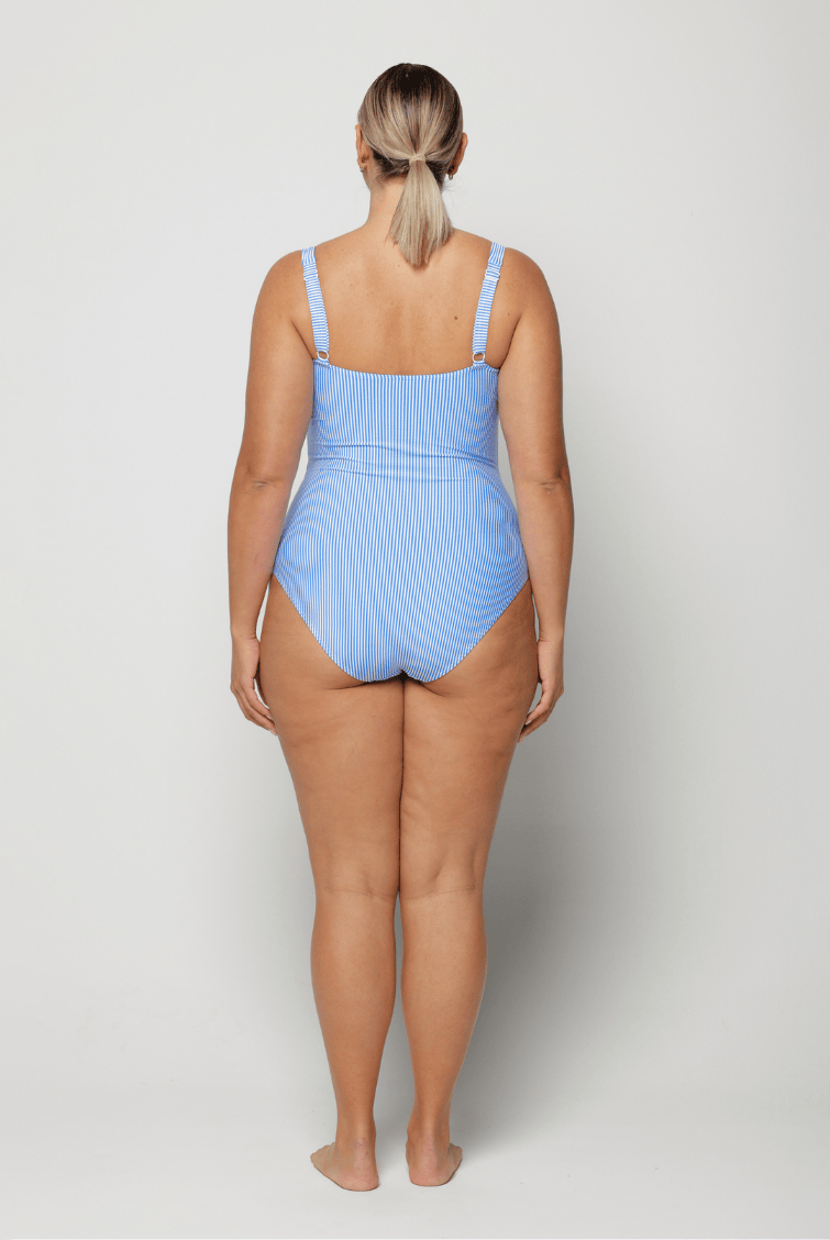 Woman wearing a blue sailor stripe swimsuit on a white background