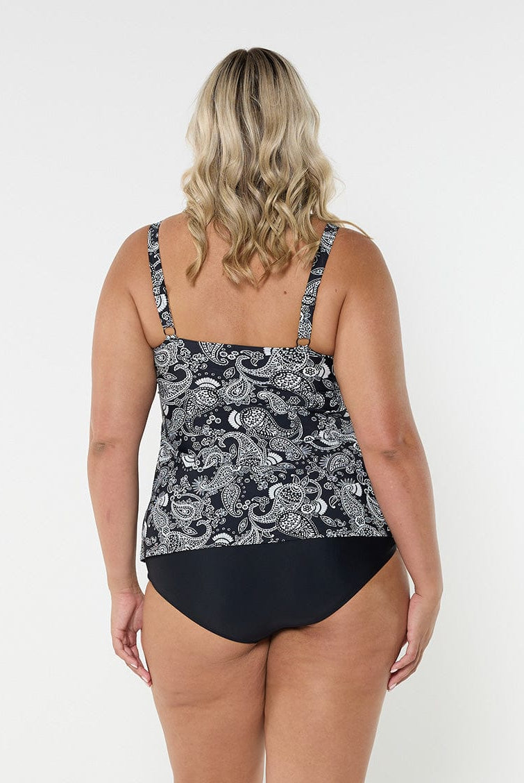 Blonde woman in studio wearing plus size tank tankini top with adjustable straps in black and white paisley print
