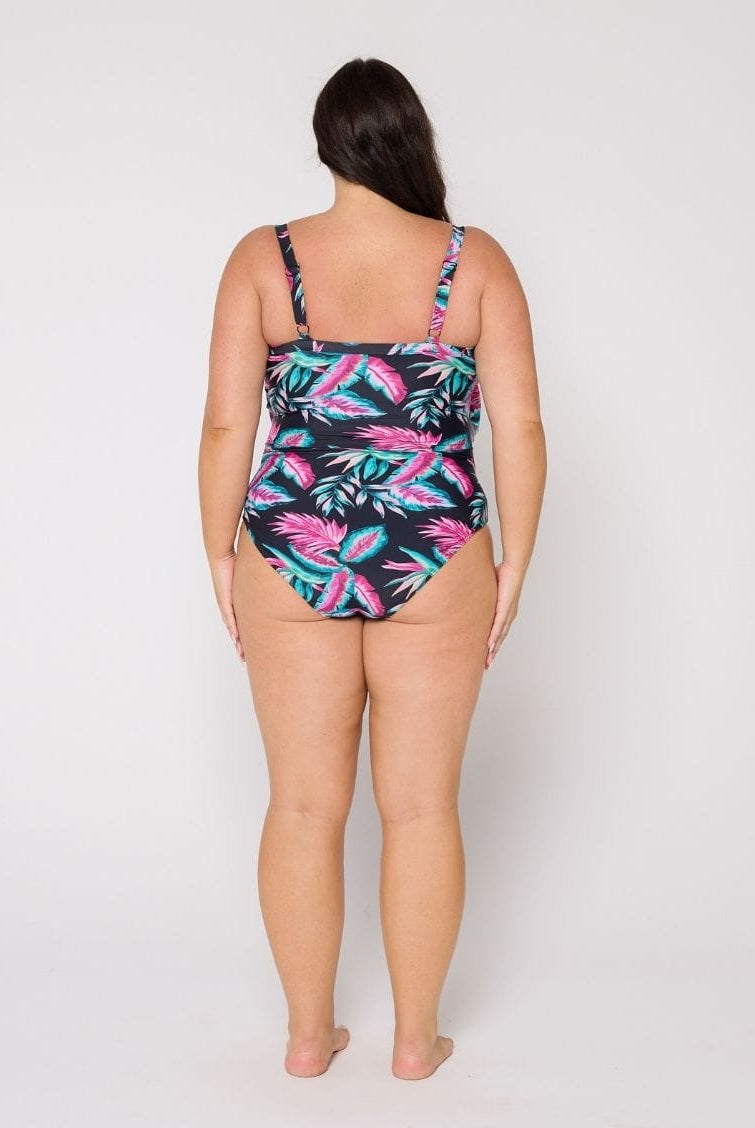 Woman wearing a 3 tier tropical print swimsuit on a white background