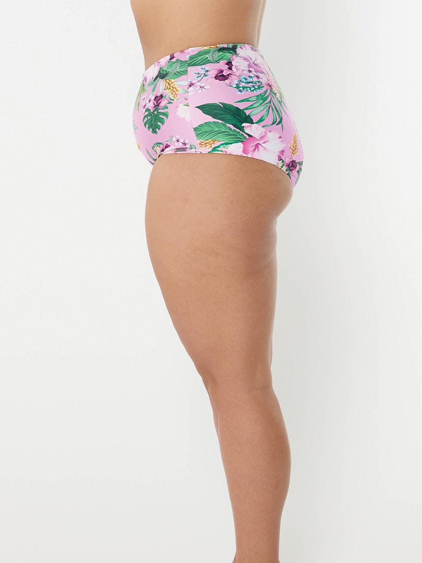 Side profile of woman wearing high waisted swim pant in tropical print for curve woman