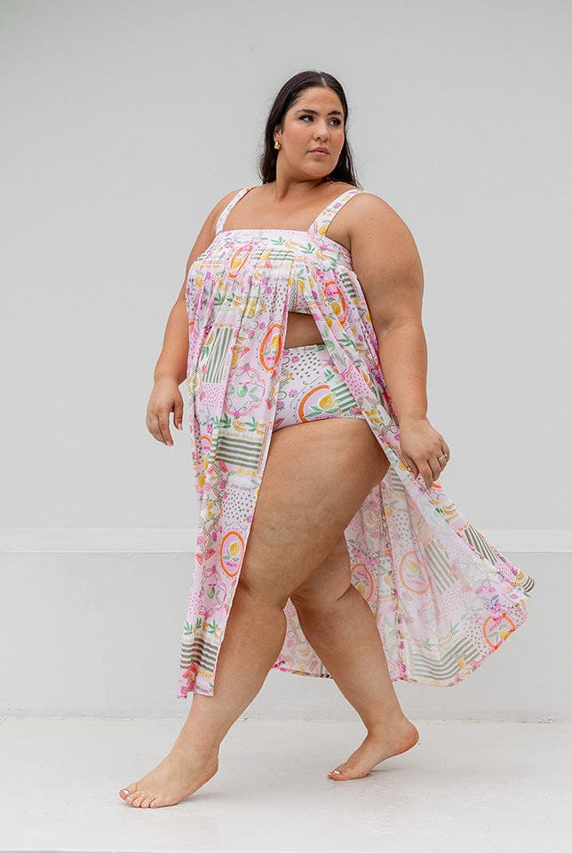 Side profile of model wearing strapless maxi beach dress with slit detail for plus size women