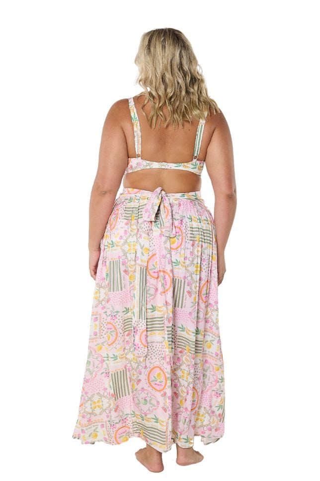 Back of model wearing plus size maxi skirt with tie detail and bright fruit coloured print
